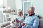 couple-senior-avec-tasse-de-the-confortable-dans-canape