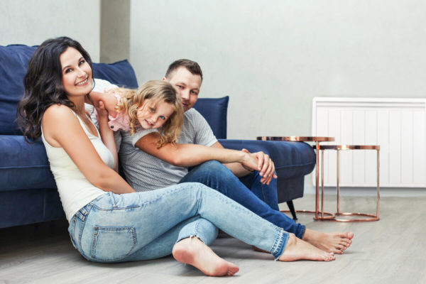 famille dans un salon avec un radiateur electrique a inertie