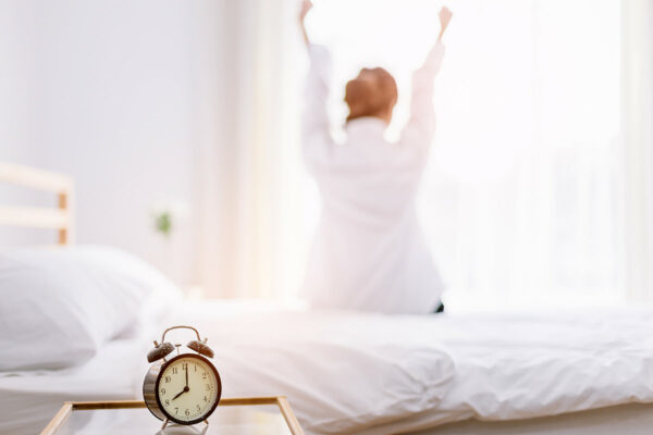 femme heureuse s etirant sur son lit le matin
