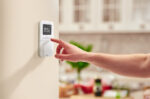 main-avec-thermostat-fixe-au-mur