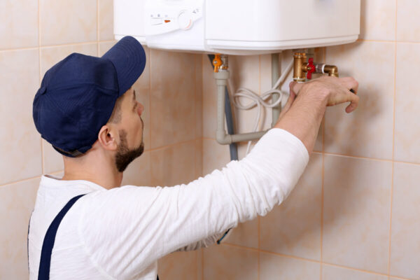 plombier qui repare un chauffe-eau